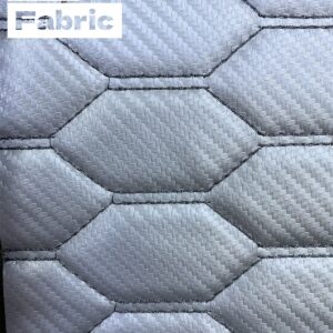 Silver patterned fabric with a subtle woven texture and hexagonal quilting. Suitable for automotive upholstery.