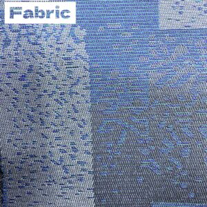 Close-up view of gray and blue patterned car fabric. The fabric has a woven texture with varying shades of gray and blue